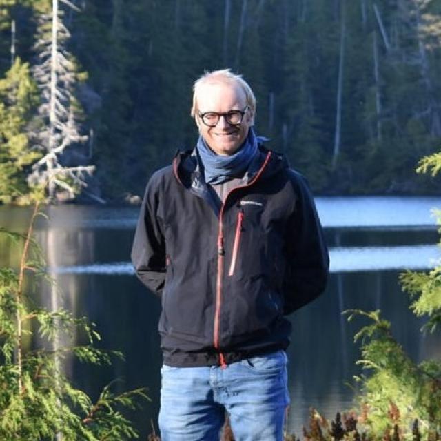 Paul vigneaux standing in front of a lake
