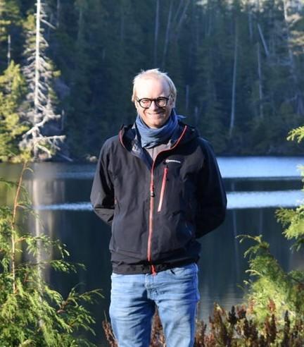 Paul vigneaux standing in front of a lake